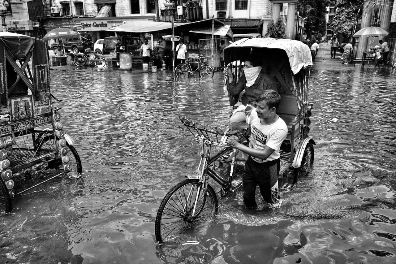 Water damage restoration Sioux City IA: View of people and vehicles on a flooded street in a city