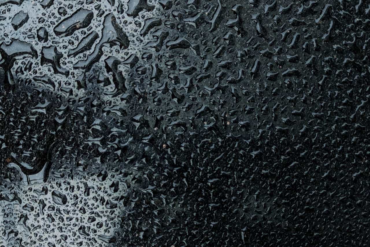 Water damage restoration in Tampa: Close up of rainwater on dark surface