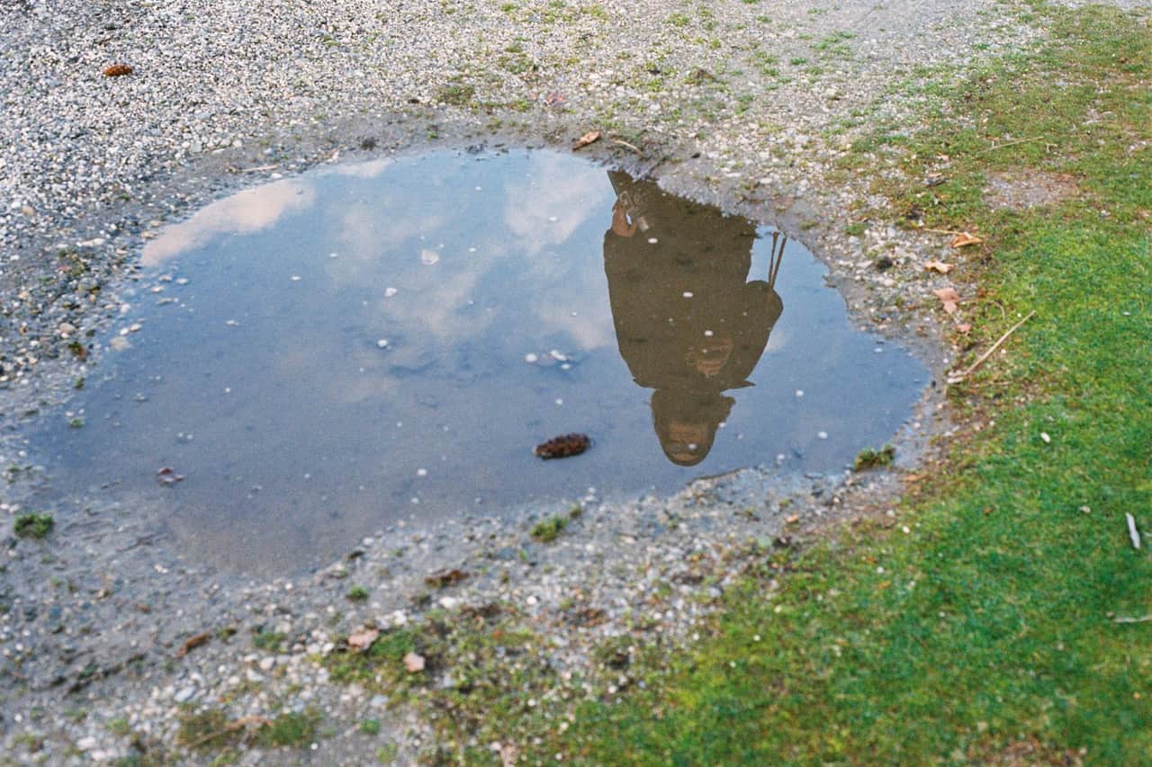 Water damage restoration Texarkana TX: Reflection of a pedestrian in a puddle on the ground
