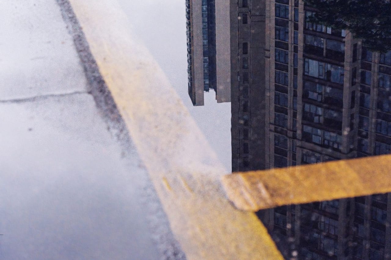Water damage restoration Waco TX: Reflection of urban skyscraper in rain puddle