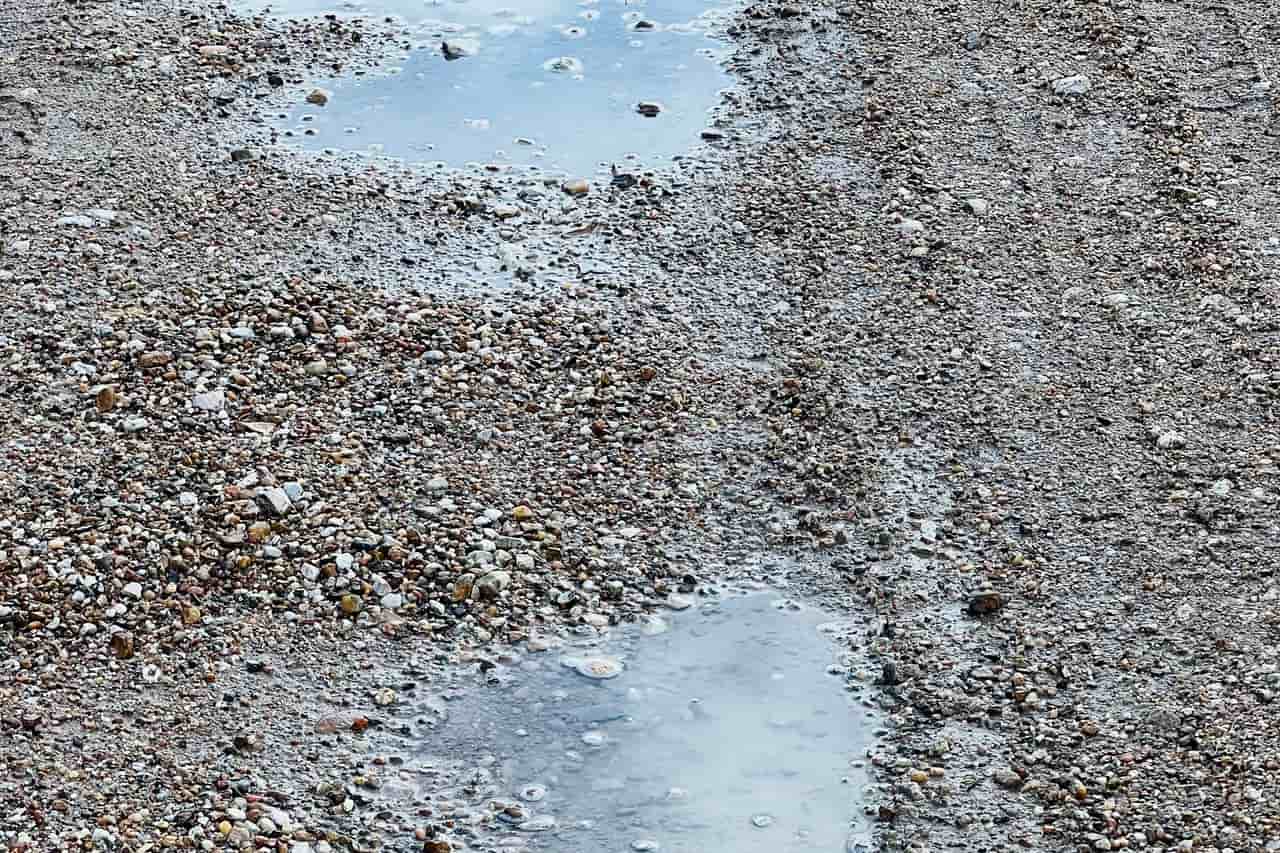 Water damage restoration Washington DC: Close up of puddles in holes in a dirt road