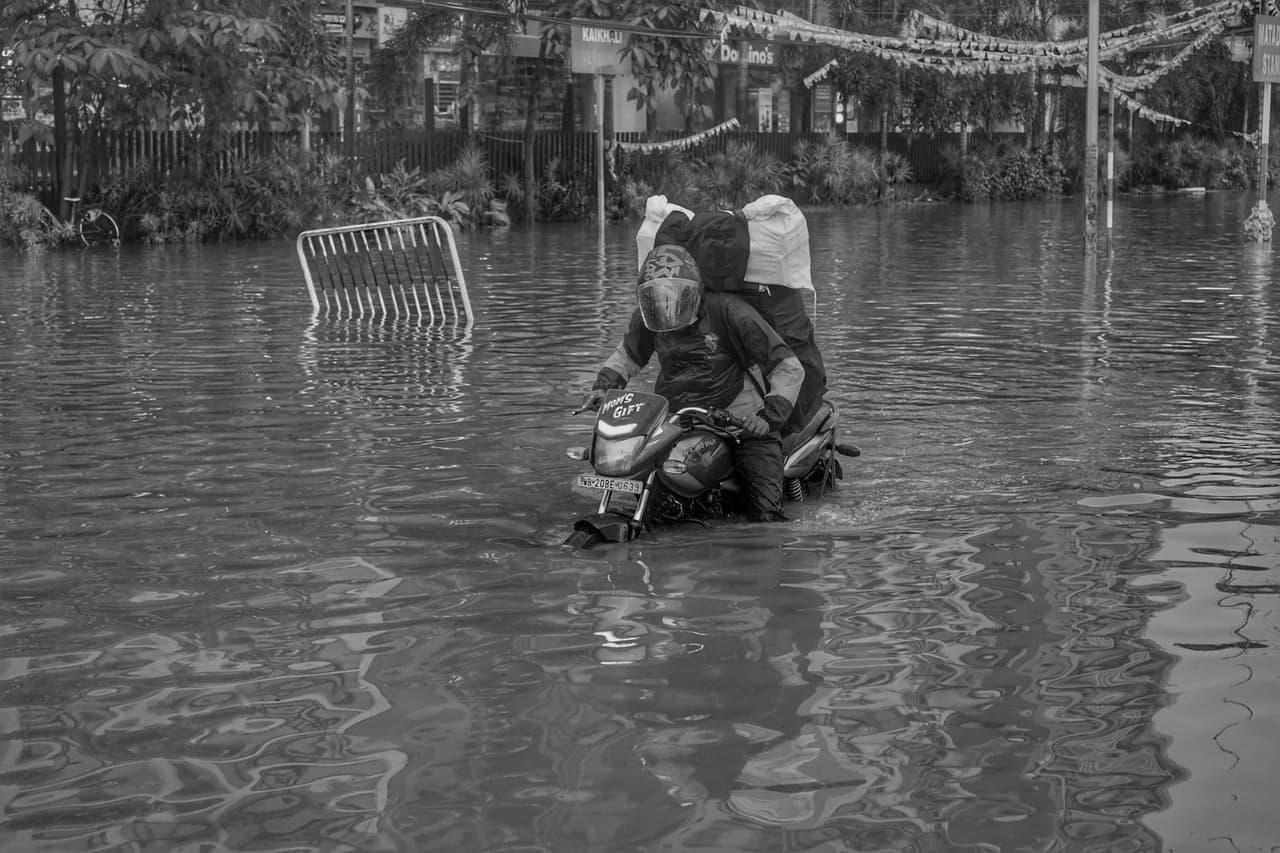 Water damage restoration Winston Salem NC: A motorcyclist riding on a flooded street